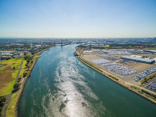 Aerial view of Yarra River and large imported cars parking lots near Port Melbourne, Victoria, Australia