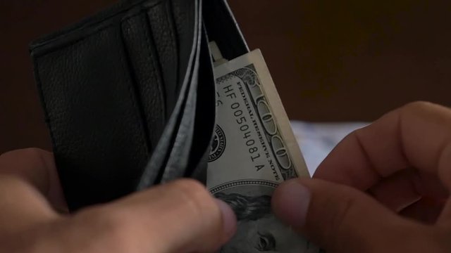Slow Motion Close-up of a businessman hands counting hundred dollar bill