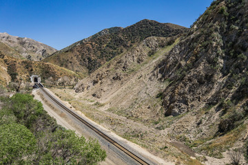 Railroad train track leads to tunnel in the San Gabriel mountains of Los Angeles County in California.