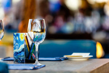 A glass of wine and some pencils is on the table in the restaurant. Illustration for the theme 