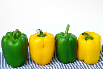 Group of sweet green peppers and yellow peppers, also known as Bell pepper or Capsicum - Fresh vegetables isolated on white background.