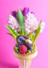 Easter composition with traditional Easter cake and chocolate egg on pink background