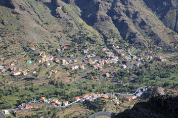 VALLE GRAN REY, LA GOMERA, SPAIN: General view of the valley with terraced fields and mountains. Winding road in the foreground