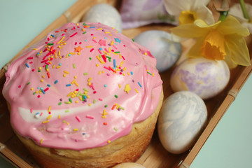 Easter cake and eggs with daffodils on a wooden platter