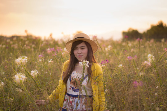 Asian woman is enjoy blow bubble at flower field during travel.