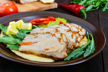 Pork baked ham, cutting slices with herbs, pepper kapi on tortilla on a ceramic plate on dark wooden background.