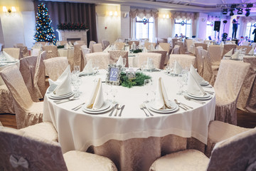 Round dinner table number 12 decorated with beige cloth