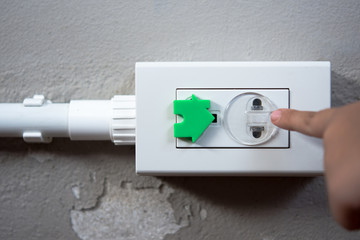 Electrical security for safety home of ac power outlet for babies, baby hands playing with electric plug.
