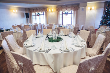 Look from above at round beige dinner table decorated with fir