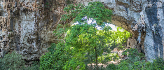 aerial photography above amazing cave. Tham Than Lod Yai is the big cave and have one hole on the top of the cave. it is a short cave there have waterfall pass inside through to another cave
