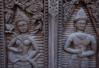 Fototapeta na wymiar Ornate wooden carvings on old temple doors Asia.