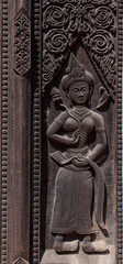 Fototapeta na wymiar Ornate wooden carvings on old temple doors Asia.