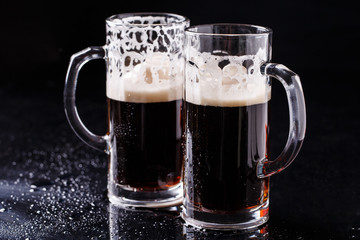 Two mugs of frothy beer