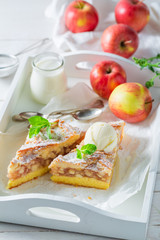 Homemade apple pie with vanilla ice cream on white table