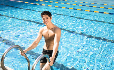 handsome smiling young man in swimming pool