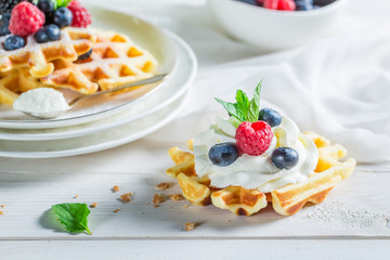 Closeup of sweet waffles with berry fruits and whipped cream