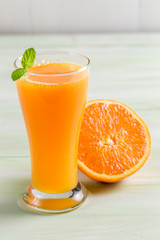 Orange juice made of fresh fruits on wooden table
