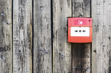 Red Fire alarm on the wooden wall background