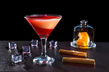 cocktail in glass on a long stalk on the bar black granite