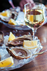 Oysters and wine. Oysters on ice with lemon. Seafood and white wine.