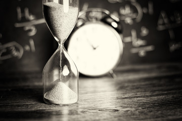 Hourglass on wood with a blackboard background