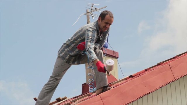 roof paints spray guns/people on the house roof painted red