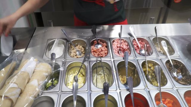 Cook prepares a dish from ingredients in the salad bar