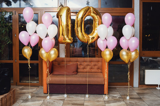 Balloons in form of number 10 hang before the couch