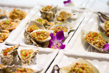 Oysters with spices on white plate with flower