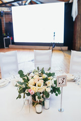 Card with number 3 put on a stick stands before vase with bouquet of roses