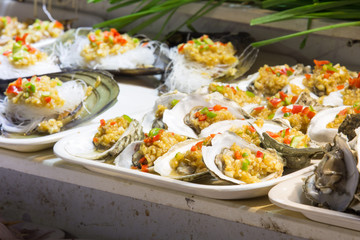 Oysters with spices on white plate. street food