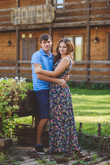 Romantic young couple hugging each other on the background of the hotel in a rustic style.