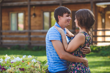 Romantic young couple hugging each other on the background of the hotel in a rustic style.