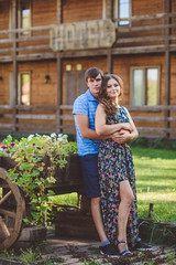 Romantic young couple hugging each other on the background of the hotel in a rustic style.