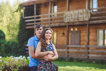 Romantic young couple hugging each other on the background of the hotel in a rustic style.
