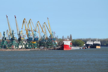 Port cargo crane and red ship. Danube river. Port 