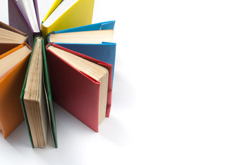 Top view of colorful hardback books in a circle. Open book, fanned pages. Back to school copy...