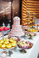 Tasty sweets and fruits on the long table