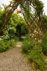 Bewachsener Torbogen mit Weg in einem Garten