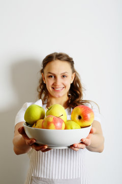 Smiling girl with a plate of fresh apples