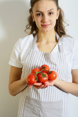 Woman chef holding a tomato in hands