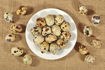 Quail eggs in a white bowl in a sacking