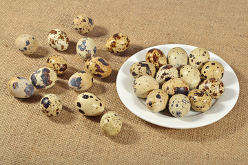 Quail eggs in a white bowl in a sacking