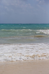 Fototapeta na wymiar Waves hitting the beach. White sand beach with turquoise sea water.