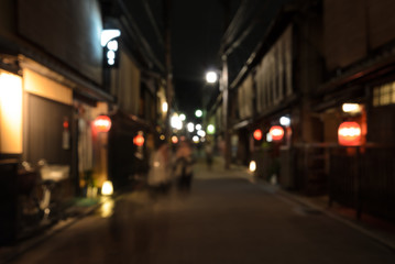 Fototapeta na wymiar Abstract blur wooden store and restaurant with lighted lanterns at night in Kyoto, Japan