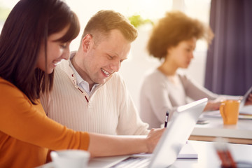 Young happy people discussing business issues in modern light office 