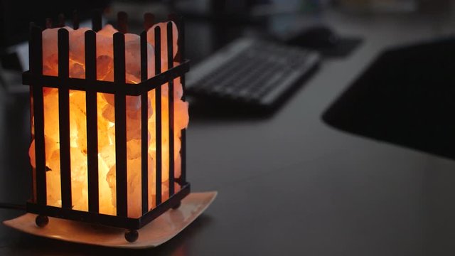 Salt Lamp Illuminated On Office Desk To Improve Health And Mood