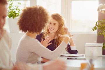 Young happy people discussing business standing at the whiteboard in modern light office, beautiful...