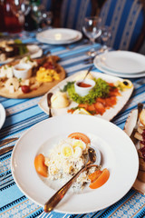 White plates with salads on stripped tablecloth