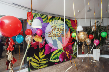 Colorful balloons hang before glass wall